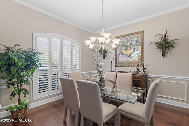 dining room with an inviting chandelier, hardwood / wood-style flooring, a wainscoted wall, and ornamental molding