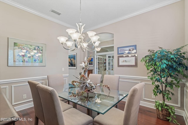 dining space featuring visible vents, crown molding, and wood finished floors