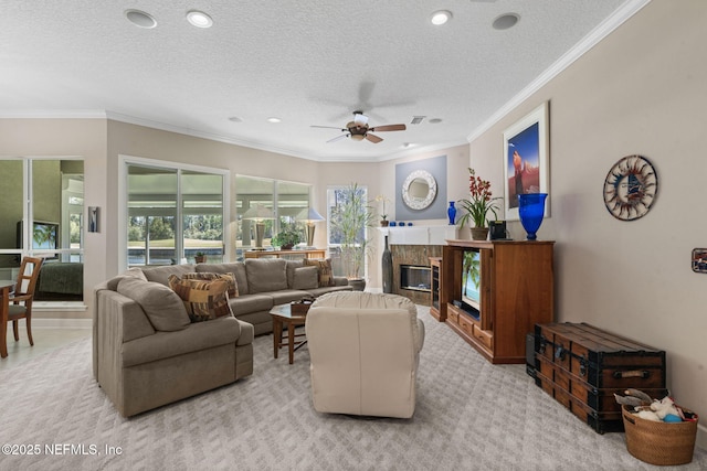 living area featuring a high end fireplace, a textured ceiling, ceiling fan, and ornamental molding