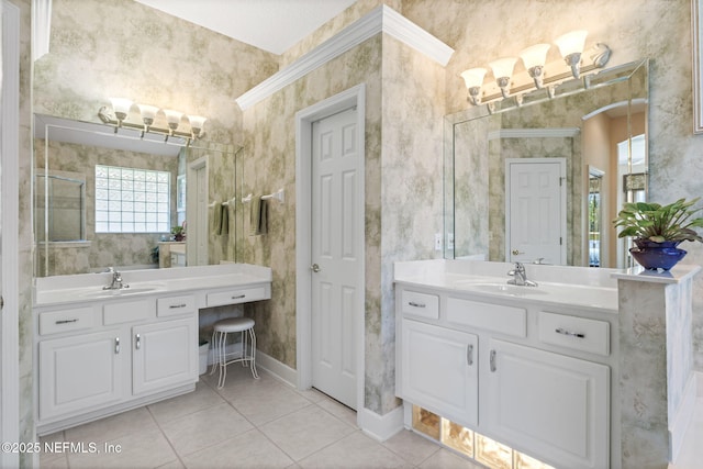 full bath with wallpapered walls, two vanities, and a sink