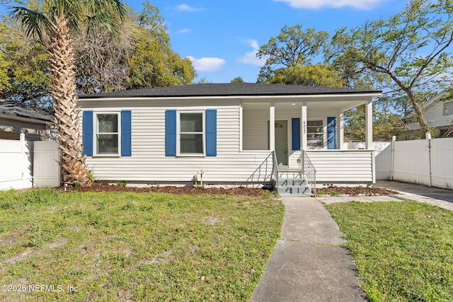 view of front of property with covered porch, a front lawn, and fence