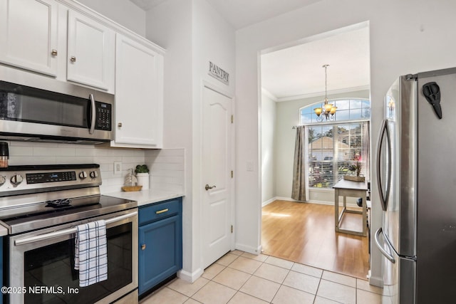 kitchen featuring blue cabinetry, backsplash, appliances with stainless steel finishes, and white cabinets