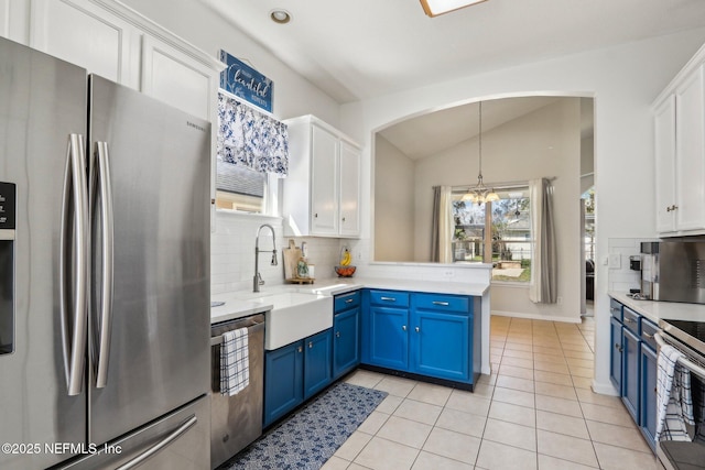 kitchen with blue cabinetry, a sink, white cabinetry, appliances with stainless steel finishes, and a chandelier