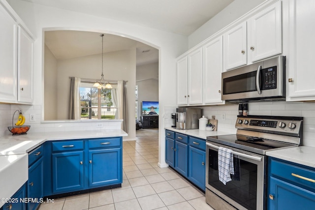 kitchen featuring blue cabinetry, arched walkways, white cabinets, and stainless steel appliances