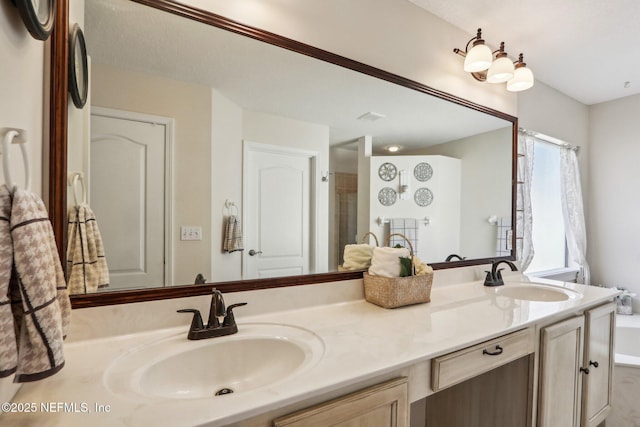 bathroom with double vanity, a shower, and a sink