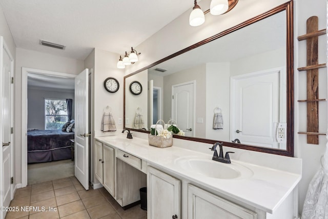 bathroom with a sink, visible vents, double vanity, and tile patterned floors