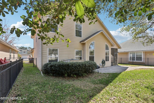 rear view of house with a yard, a patio area, and a fenced backyard