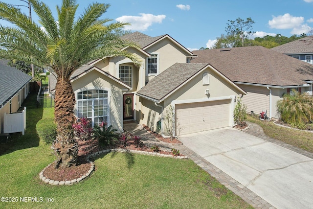 traditional-style home with fence, concrete driveway, a front yard, stucco siding, and a garage