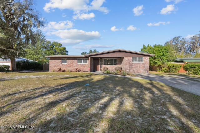 single story home with a front yard and brick siding