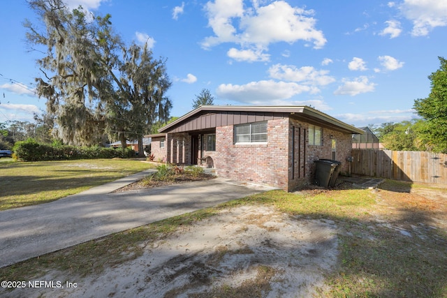 1516 Prospect St, Palatka, FL 32177 - view of side of home featuring fence, a yard, brick siding, concrete driveway, and board and batten siding