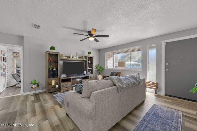 1516 Prospect St, Palatka, FL 32177 - living room featuring visible vents, a textured ceiling, ceiling fan, and wood finished floors