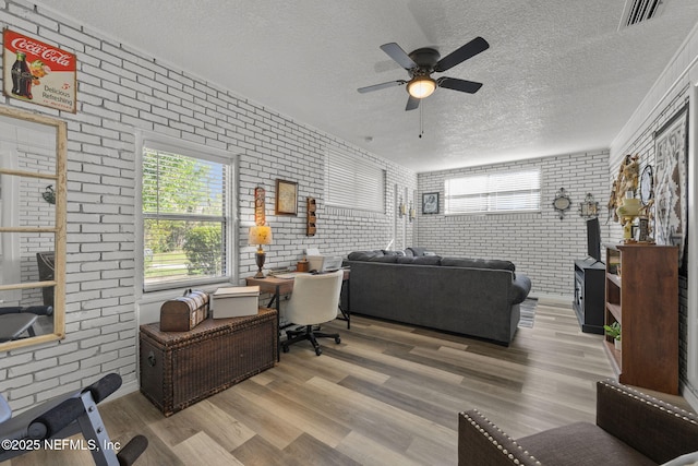 1516 Prospect St, Palatka, FL 32177 - living room featuring visible vents, brick wall, a textured ceiling, and wood finished floors