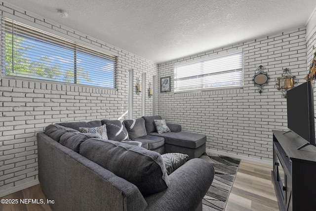 1516 Prospect St, Palatka, FL 32177 - living room featuring light wood finished floors, brick wall, and a textured ceiling