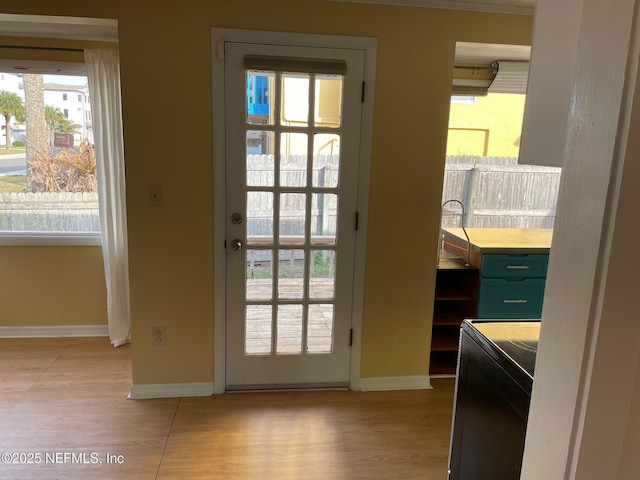 doorway to outside with baseboards and washer / clothes dryer