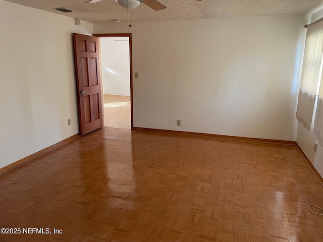 unfurnished room featuring baseboards, visible vents, a textured ceiling, and ceiling fan