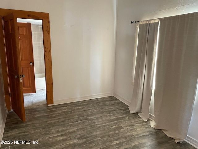 unfurnished room featuring dark wood finished floors and baseboards