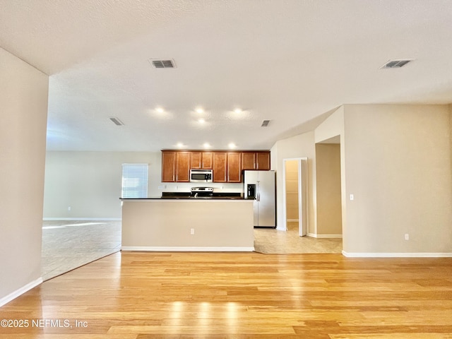 kitchen with visible vents, dark countertops, appliances with stainless steel finishes, and light wood-style flooring