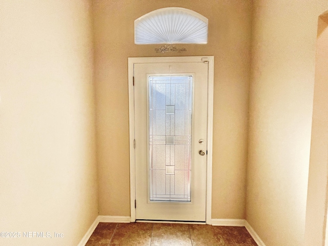 doorway to outside featuring tile patterned flooring and baseboards