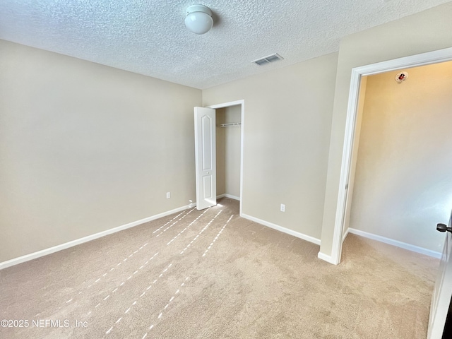 unfurnished bedroom featuring visible vents, baseboards, a closet, and carpet flooring