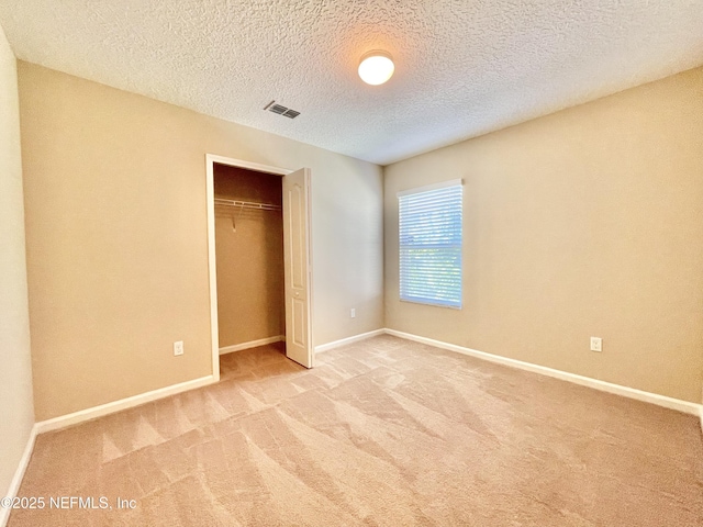 unfurnished bedroom with visible vents, baseboards, carpet, and a closet