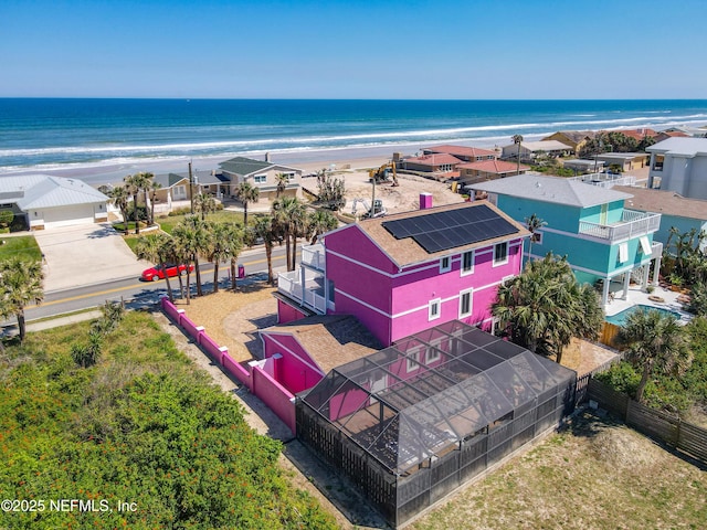 drone / aerial view with a residential view, a water view, and a beach view