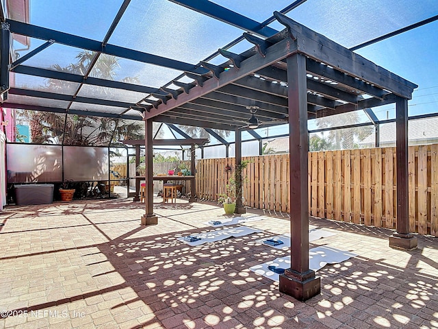 view of patio / terrace with a lanai, a pergola, and fence