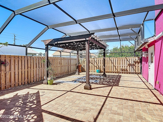 view of patio featuring glass enclosure and a fenced backyard