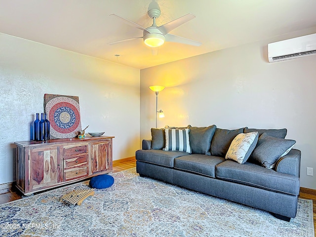 living area with a ceiling fan, a wall unit AC, wood finished floors, and baseboards