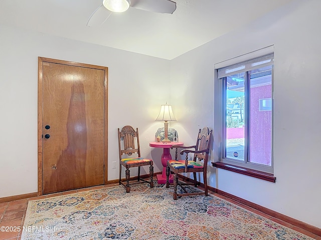 sitting room with baseboards and a ceiling fan