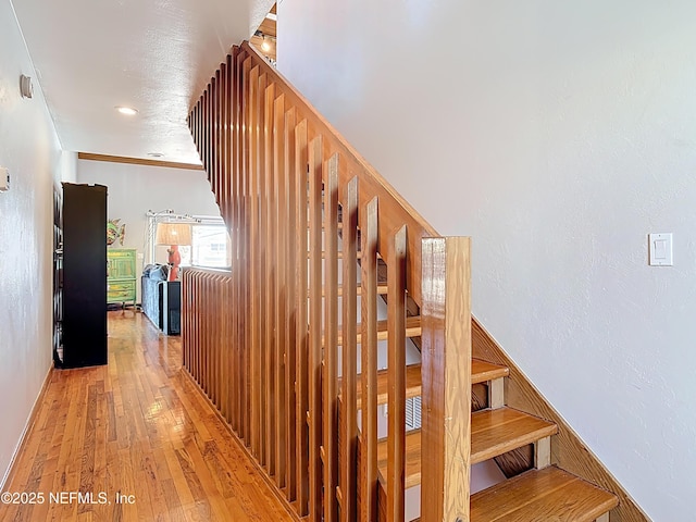 stairway featuring hardwood / wood-style floors and crown molding