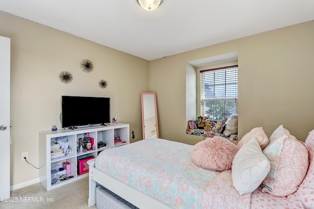 bedroom with light carpet and baseboards