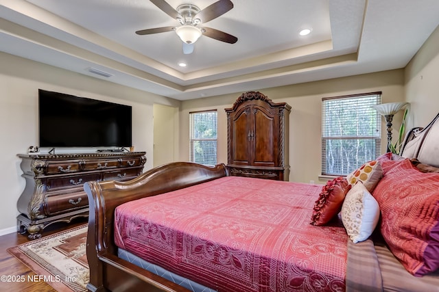 bedroom featuring visible vents, recessed lighting, wood finished floors, a raised ceiling, and a ceiling fan