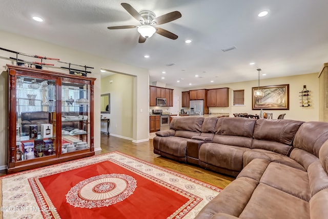 living area with recessed lighting, visible vents, wood finished floors, and ceiling fan