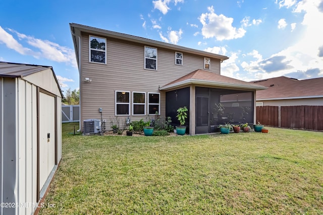 rear view of house with a yard, central air condition unit, a fenced backyard, and a sunroom