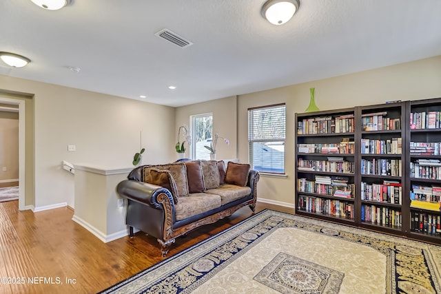 living room featuring recessed lighting, visible vents, baseboards, and wood finished floors