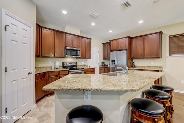 kitchen featuring visible vents, a breakfast bar area, and stainless steel appliances