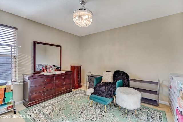 bedroom with baseboards and a chandelier