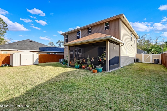 rear view of property featuring an outbuilding, a shed, a fenced backyard, and a sunroom