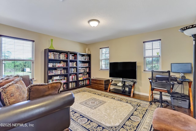 living room featuring plenty of natural light, baseboards, and wood finished floors