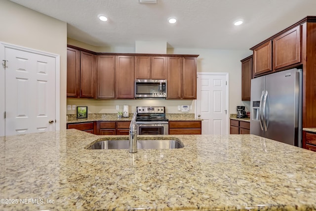 kitchen featuring light stone counters, recessed lighting, and appliances with stainless steel finishes