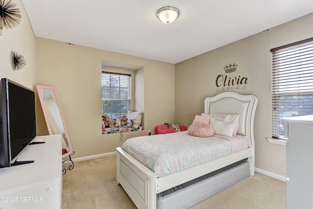 bedroom with light colored carpet and baseboards