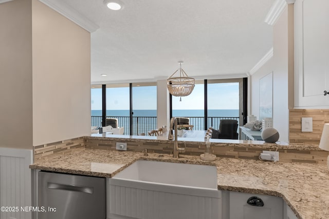 kitchen featuring a sink, decorative backsplash, a water view, and dishwasher