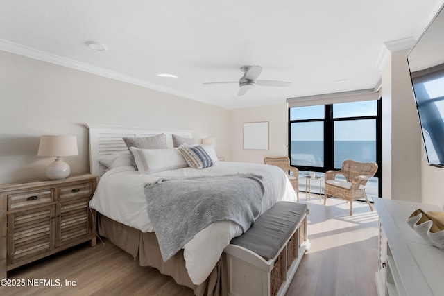 bedroom featuring ceiling fan, wood finished floors, and ornamental molding