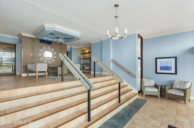 staircase featuring a notable chandelier, baseboards, and ornamental molding