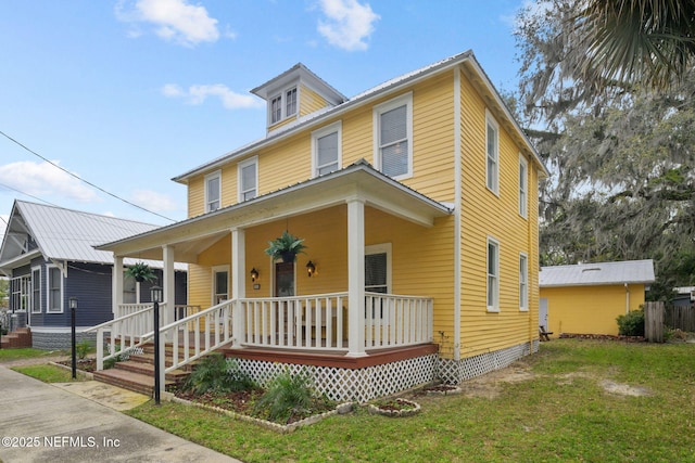 traditional style home featuring covered porch and a front yard