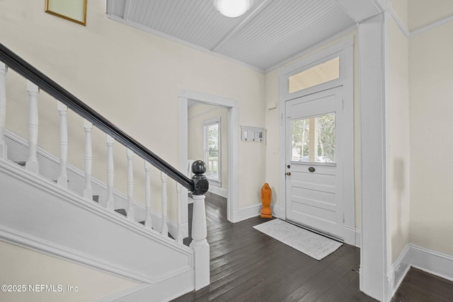 foyer featuring a wealth of natural light, stairway, baseboards, and dark wood-style flooring