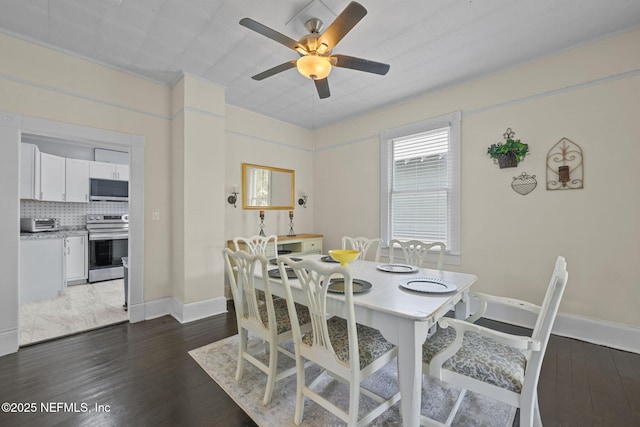 dining room featuring a toaster, ceiling fan, baseboards, and dark wood-style flooring