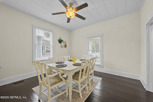 dining area featuring dark wood finished floors, visible vents, ceiling fan, and baseboards