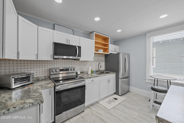 kitchen featuring a sink, backsplash, a toaster, appliances with stainless steel finishes, and open shelves