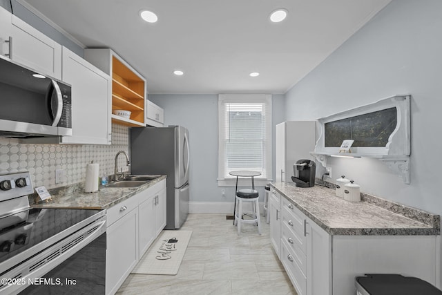 kitchen featuring open shelves, a sink, white cabinets, appliances with stainless steel finishes, and backsplash